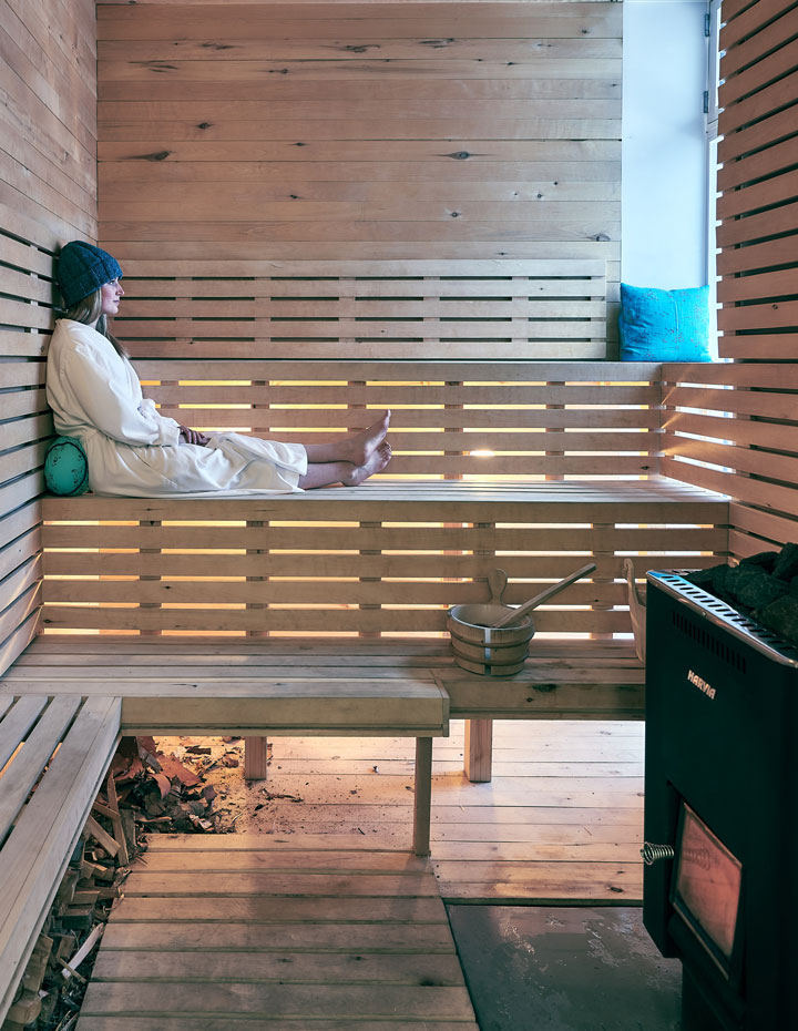 Woman looking out the window in a sauna at the Fogo Island Inn